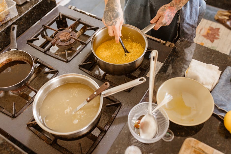 Professional chef stirring ingredients on a gas stove in a modern kitchen setting, showcasing skillful culinary preparation.