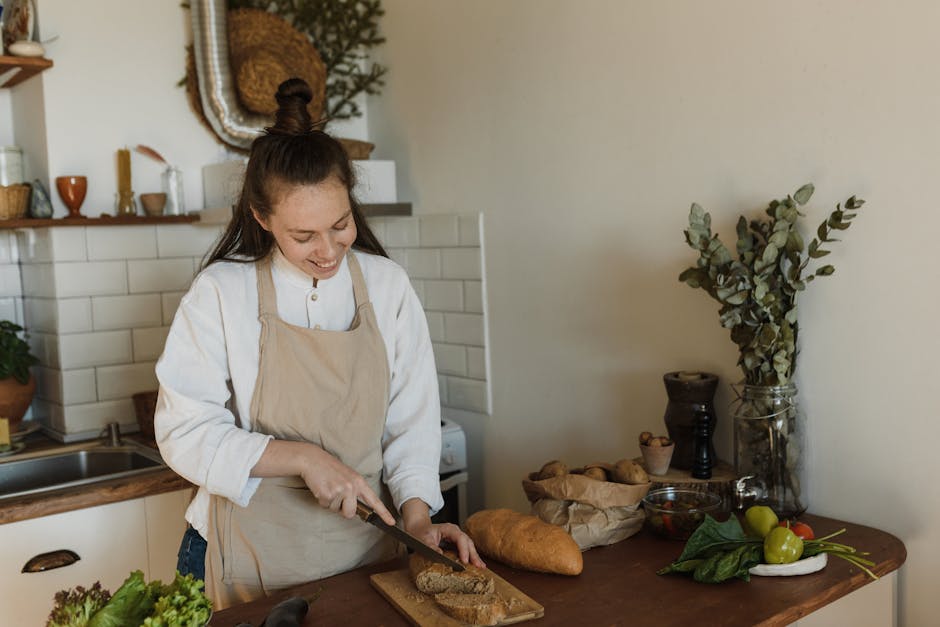 A cheerful woman slices bread in a warm, inviting kitchen. Perfect for lifestyle and culinary themes.